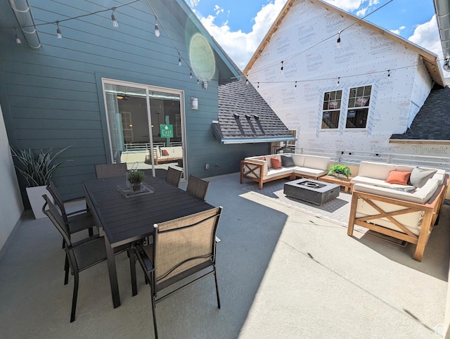 view of patio with outdoor dining space and an outdoor living space with a fire pit