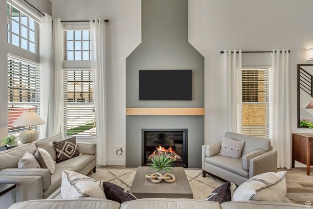 6807 W S Jordan Pkwy S Unit 251, South Jordan, UT 84009 - living room featuring a towering ceiling, a glass covered fireplace, and wood finished floors