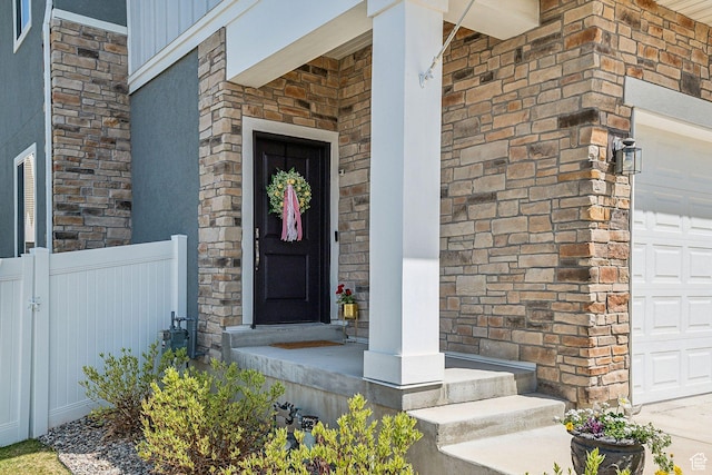 property entrance featuring fence, a porch, and stone siding