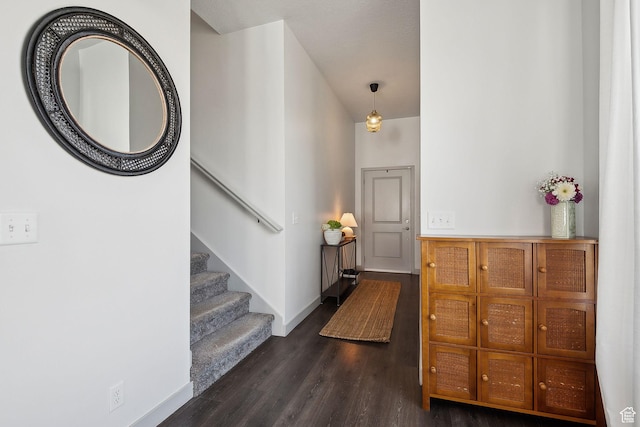 foyer with baseboards, stairs, and dark wood-style flooring