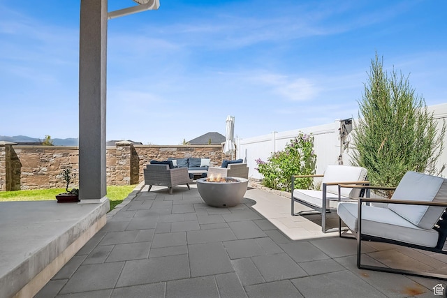 view of patio with an outdoor living space with a fire pit and a fenced backyard