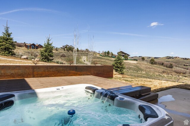 view of pool featuring a wooden deck and hot tub deck surround