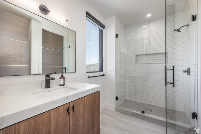 bathroom with a shower stall, baseboards, and vanity