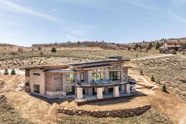 back of property featuring a wooden deck and a patio