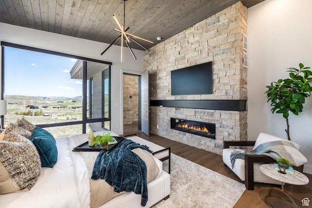 living room with an inviting chandelier, wooden ceiling, wood finished floors, and a fireplace