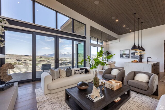 living area featuring wood finished floors, wooden ceiling, a high ceiling, a mountain view, and recessed lighting