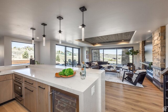 9881 N Uinta Dr, Kamas, UT 84036 - kitchen with wine cooler, a healthy amount of sunlight, light wood-type flooring, light stone countertops, and open floor plan