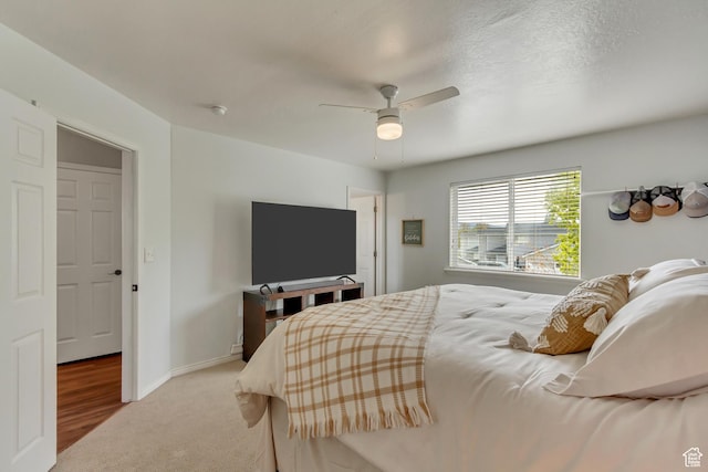 carpeted bedroom with a ceiling fan and baseboards