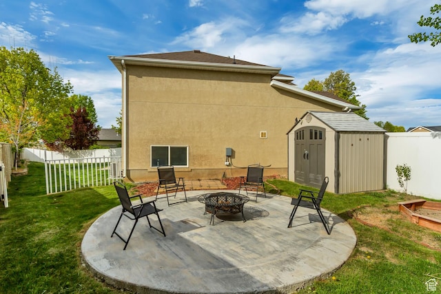 view of patio / terrace with a storage shed, a fenced backyard, an outdoor fire pit, and an outdoor structure