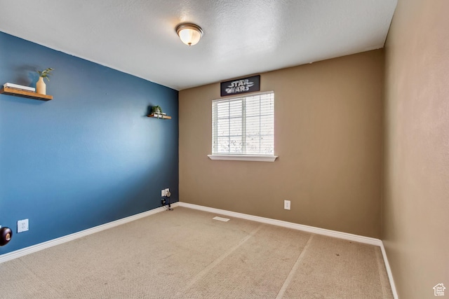 unfurnished room with baseboards and carpet floors