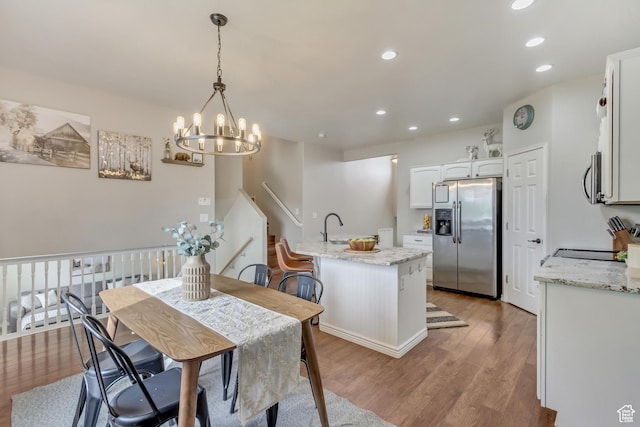 dining area with wood finished floors, recessed lighting, and a chandelier