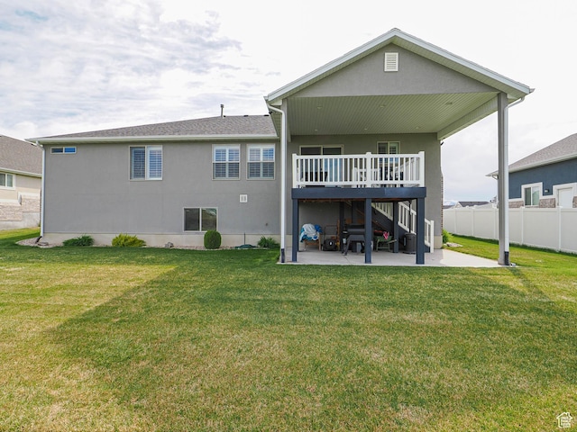 rear view of property with a lawn, fence, a deck, and a patio