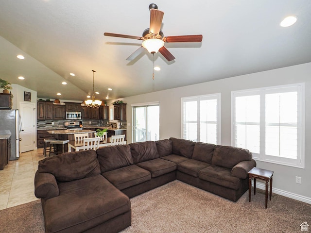 living room featuring light carpet, vaulted ceiling, baseboards, recessed lighting, and ceiling fan with notable chandelier