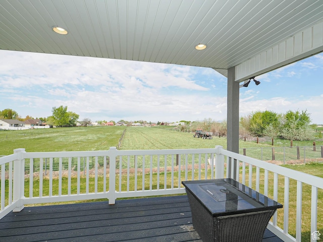 wooden deck featuring a rural view and a lawn