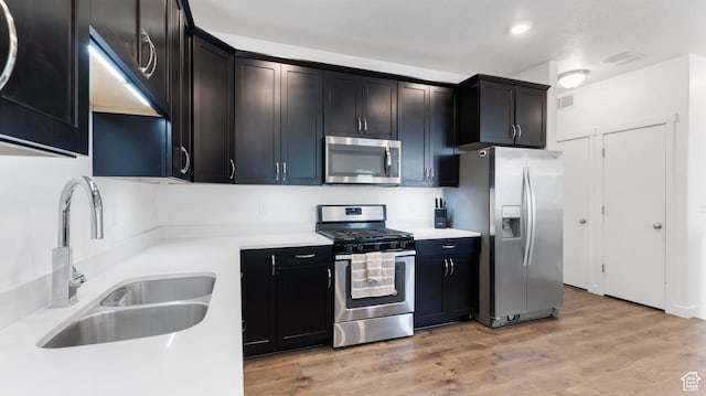 kitchen with light wood-style flooring, a sink, visible vents, light countertops, and appliances with stainless steel finishes