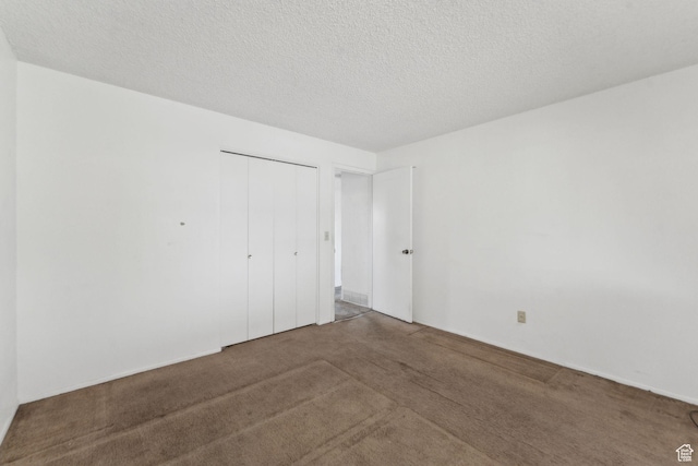 unfurnished bedroom featuring carpet floors, a closet, and a textured ceiling