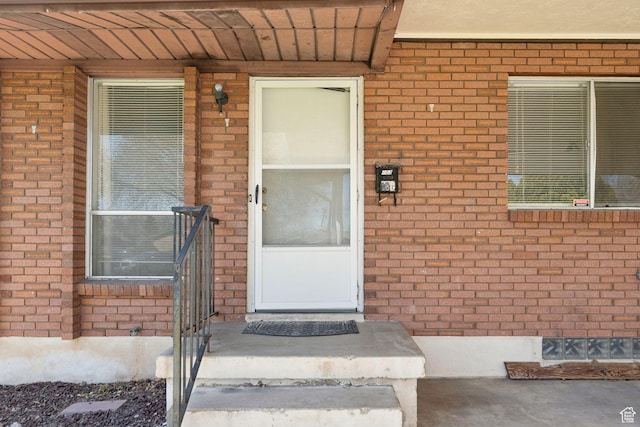view of exterior entry featuring brick siding