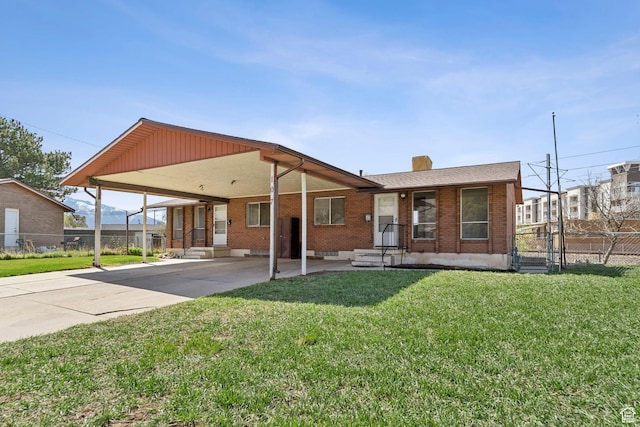 exterior space with driveway, a front yard, a carport, brick siding, and fence