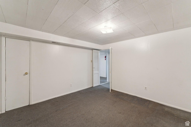 finished basement with baseboards and dark carpet