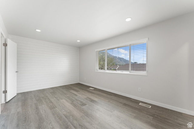 spare room with recessed lighting, wood finished floors, visible vents, and baseboards