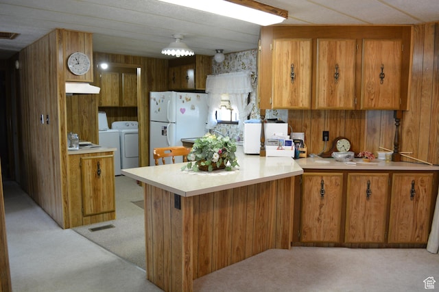 595 N 6th St, Montpelier, ID 83254 - kitchen with separate washer and dryer, light carpet, a peninsula, and brown cabinets