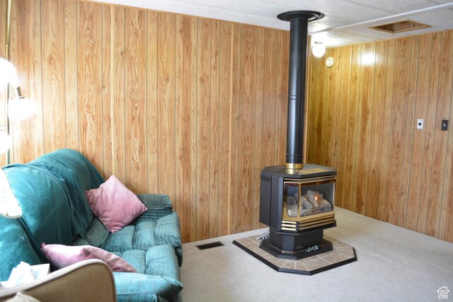 595 N 6th St, Montpelier, ID 83254 - carpeted living room with wooden walls, visible vents, and a wood stove