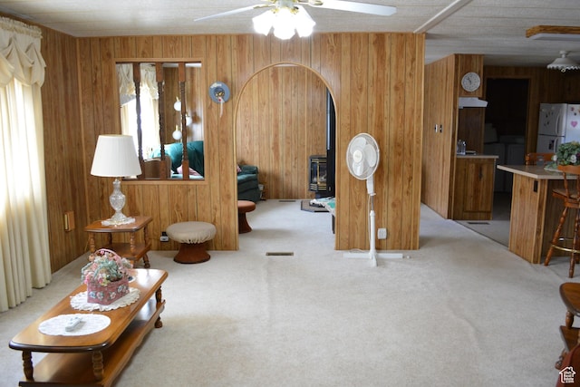 595 N 6th St, Montpelier, ID 83254 - living area with ceiling fan, a wood stove, wooden walls, and carpet