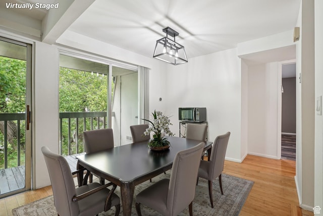 dining space featuring light wood-style flooring and baseboards
