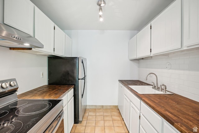 kitchen with stainless steel appliances, butcher block counters, a sink, decorative backsplash, and white cabinetry