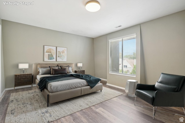 bedroom with wood finished floors and baseboards