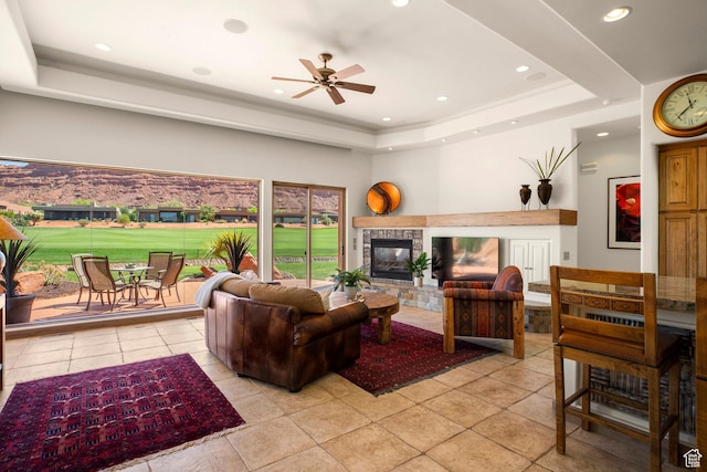2410 W Entrada Trl Unit 15, St George, UT 84770 - living area with a ceiling fan, a tray ceiling, a fireplace, and light tile patterned flooring