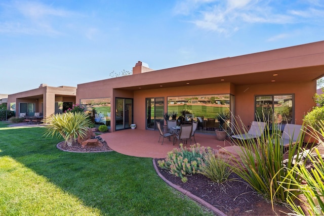 2410 W Entrada Trl Unit 15, St George, UT 84770 - back of property with stucco siding, a lawn, a chimney, and a patio