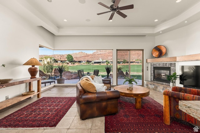 2410 W Entrada Trl Unit 15, St George, UT 84770 - living area featuring a ceiling fan, tile patterned floors, a glass covered fireplace, a tray ceiling, and recessed lighting