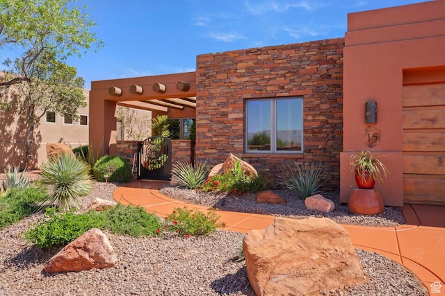 2410 W Entrada Trl Unit 15, St George, UT 84770 - exterior space with a gate and stone siding