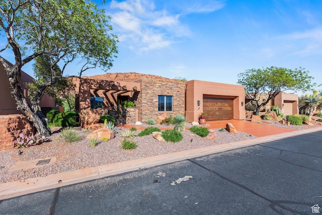 2410 W Entrada Trl Unit 15, St George, UT 84770 - pueblo revival-style home featuring stucco siding, driveway, stone siding, and a garage