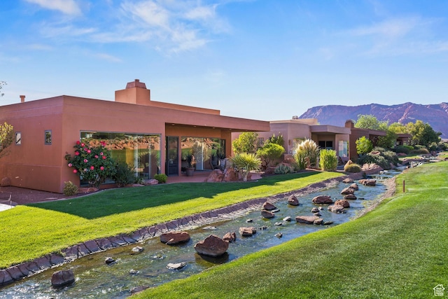 2410 W Entrada Trl Unit 15, St George, UT 84770 - pueblo-style house featuring a front lawn, a mountain view, and stucco siding