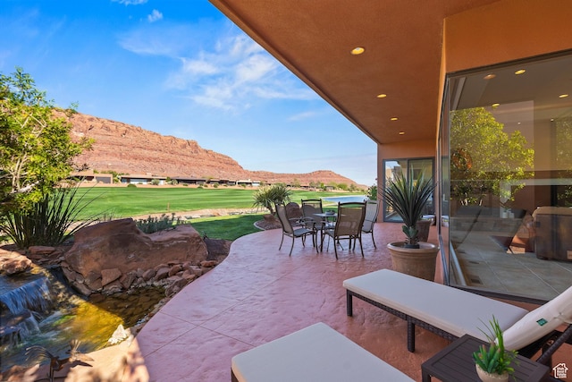 2410 W Entrada Trl Unit 15, St George, UT 84770 - view of patio with outdoor dining area and a mountain view