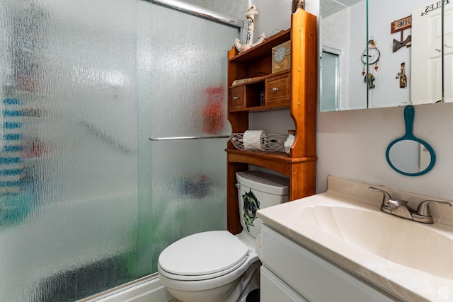 bathroom with vanity, a shower with shower door, and toilet