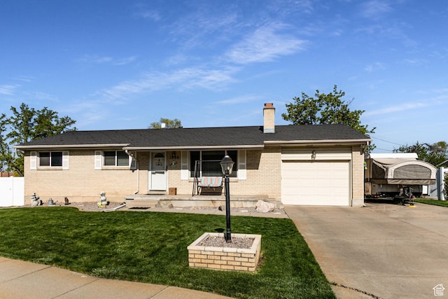 ranch-style house featuring a chimney, concrete driveway, brick siding, a front yard, and a garage
