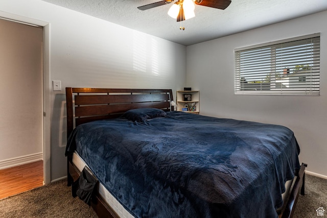 bedroom featuring baseboards, a ceiling fan, carpet flooring, and a textured ceiling