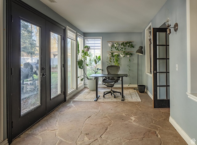 home office with stone floors, baseboards, and french doors