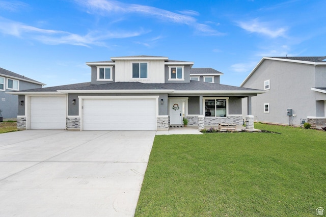 prairie-style house featuring a front lawn, stone siding, covered porch, concrete driveway, and a garage