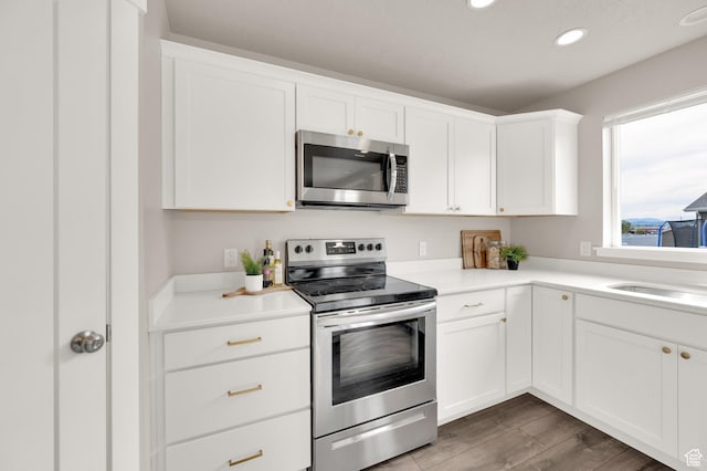 227 N 250 E, Salem, UT 84653 - kitchen featuring wood finished floors, a sink, white cabinetry, appliances with stainless steel finishes, and recessed lighting