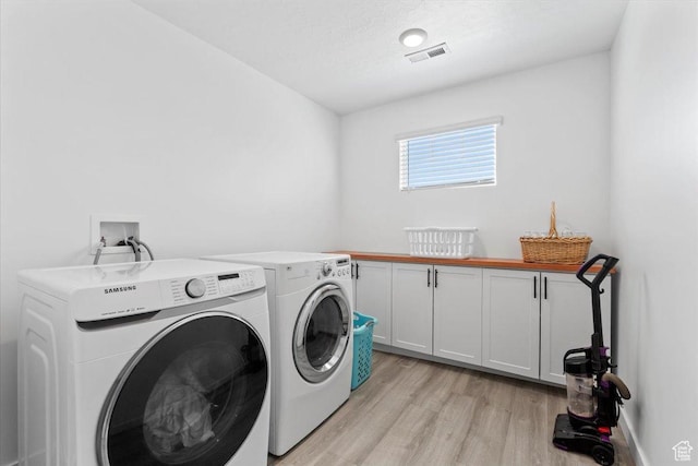 1158 E Bearing Dr S, Saratoga Springs, UT 84045 - washroom featuring cabinet space, light wood-style floors, visible vents, and washer and clothes dryer