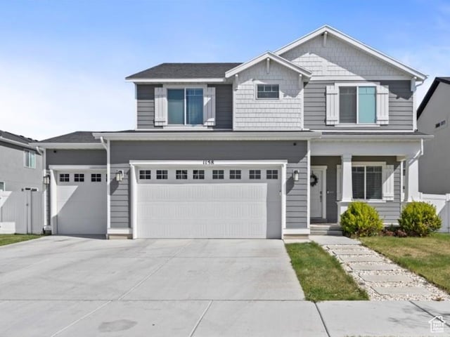 1158 E Bearing Dr S, Saratoga Springs, UT 84045 - view of front of house featuring an attached garage, driveway, covered porch, and fence