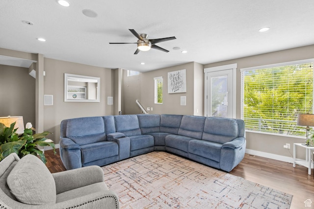 living area with recessed lighting, plenty of natural light, a ceiling fan, and baseboards