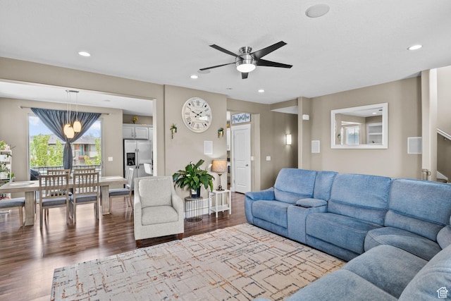 living room with a ceiling fan, recessed lighting, and dark wood-type flooring
