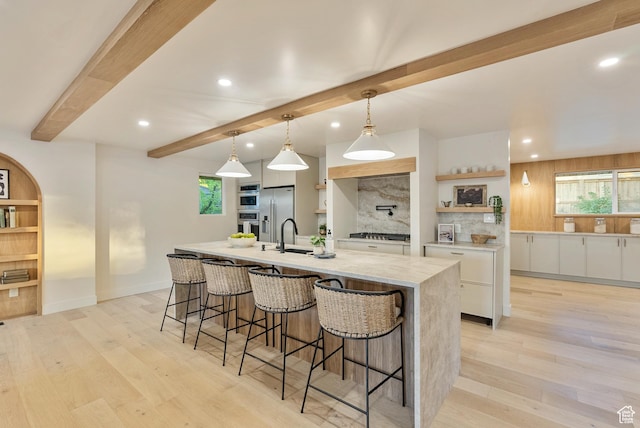 1075 S Alton Way E, Salt Lake City, UT 84108 - kitchen with stainless steel appliances, beam ceiling, a spacious island, white cabinetry, and a breakfast bar area