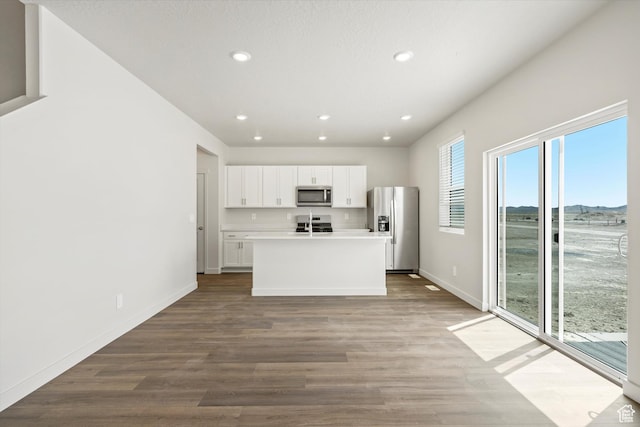 3509 N Gina St Unit 1230, Eagle Mountain, UT 84005 - kitchen featuring appliances with stainless steel finishes, white cabinets, recessed lighting, wood finished floors, and an island with sink