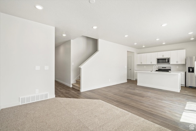 3509 N Gina St Unit 1230, Eagle Mountain, UT 84005 - unfurnished living room featuring light wood-type flooring, recessed lighting, and stairway
